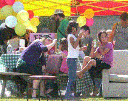 A community BBQ, with balloons and face-painting.