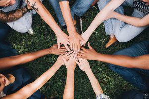 Team members putting their hands in to the centre of the circle.