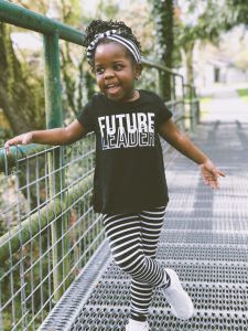 Child wearing a t-shirt that says "Future Leader" on it.